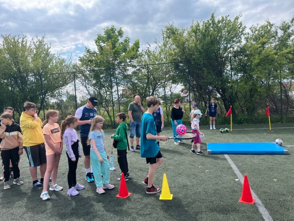 Dzieci uczestniczą w zajęciach sportowych na zewnątrz