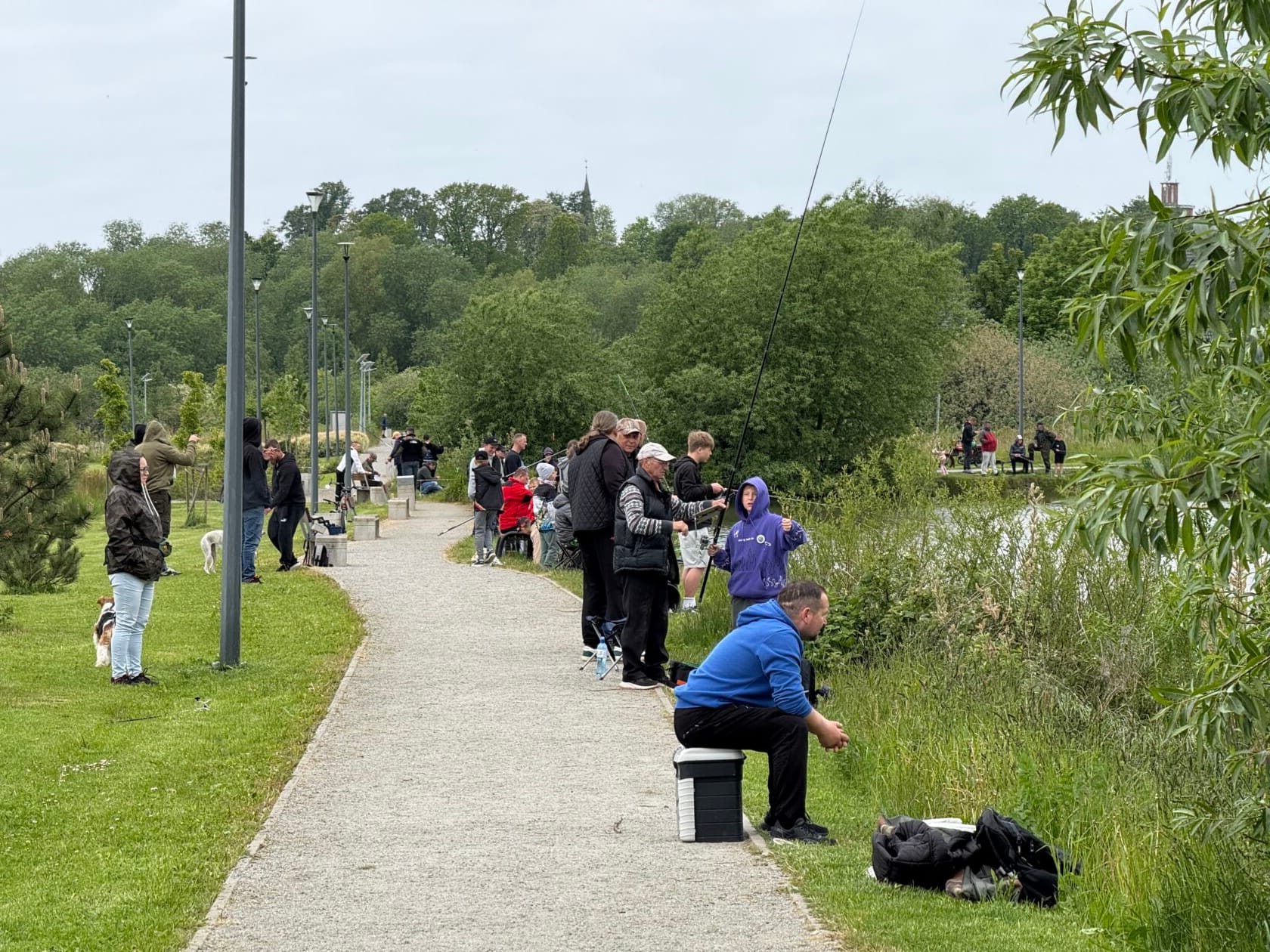 Ludzie łowią ryby nad jeziorem w parku