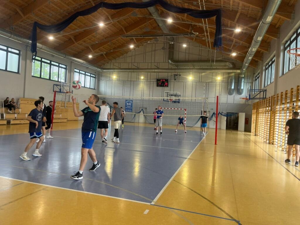 Ludzie grają w siatkówkę w hali sportowej