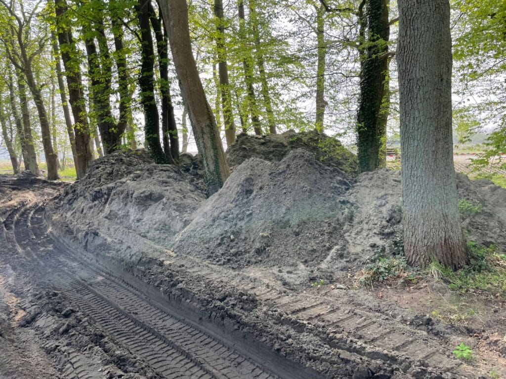 Ścieżka z błotem między kopcami ziemi w lesie