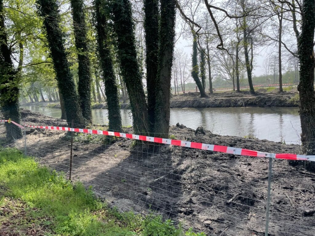 Zakazany teren przy rzece otoczony drzewami