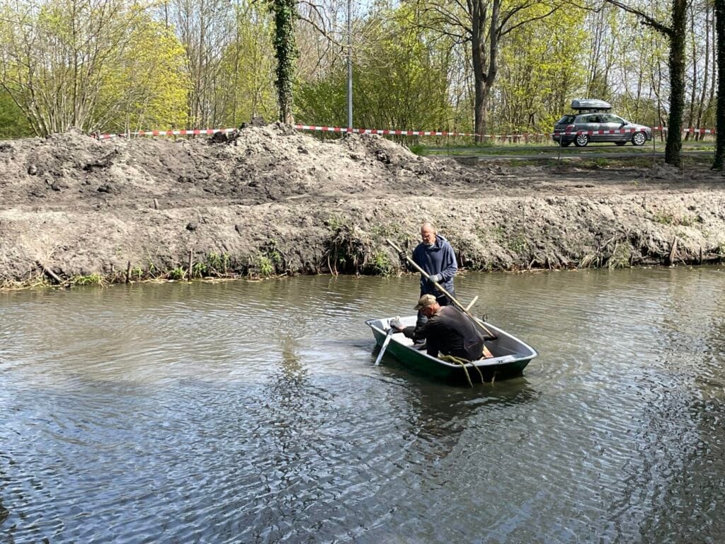 Dwóch mężczyzn w łódce na rzece blisko brzegu