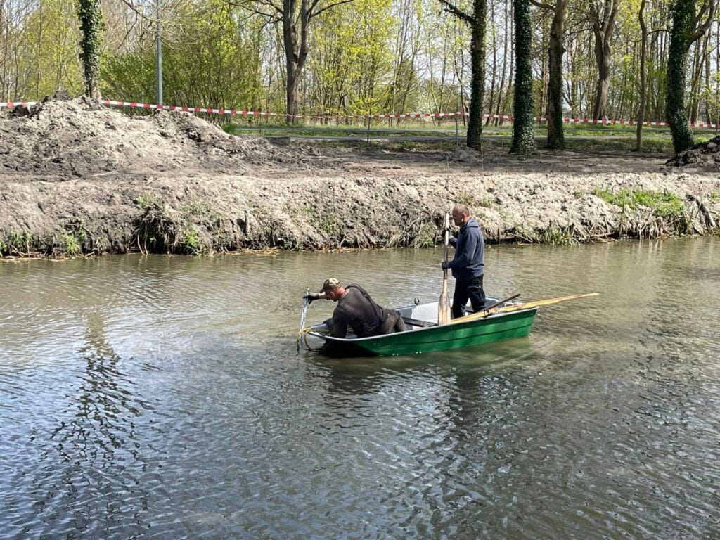 Dwóch mężczyzn w łodzi na rzece, prace na wodzie