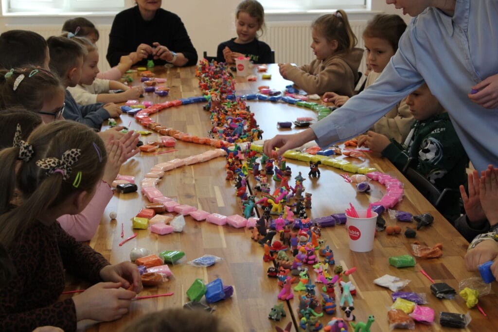 Dzieci uczestniczą w warsztacie plastycznym z modeliną