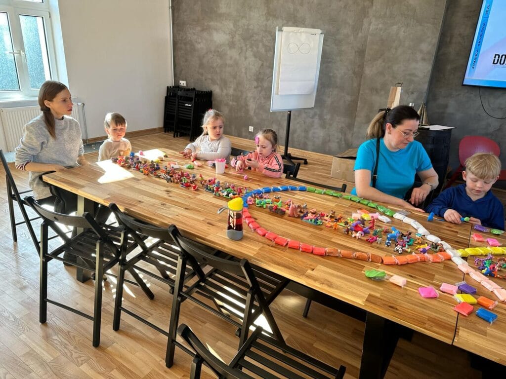 Rodzina bawi się klockami na dużym drewnianym stole