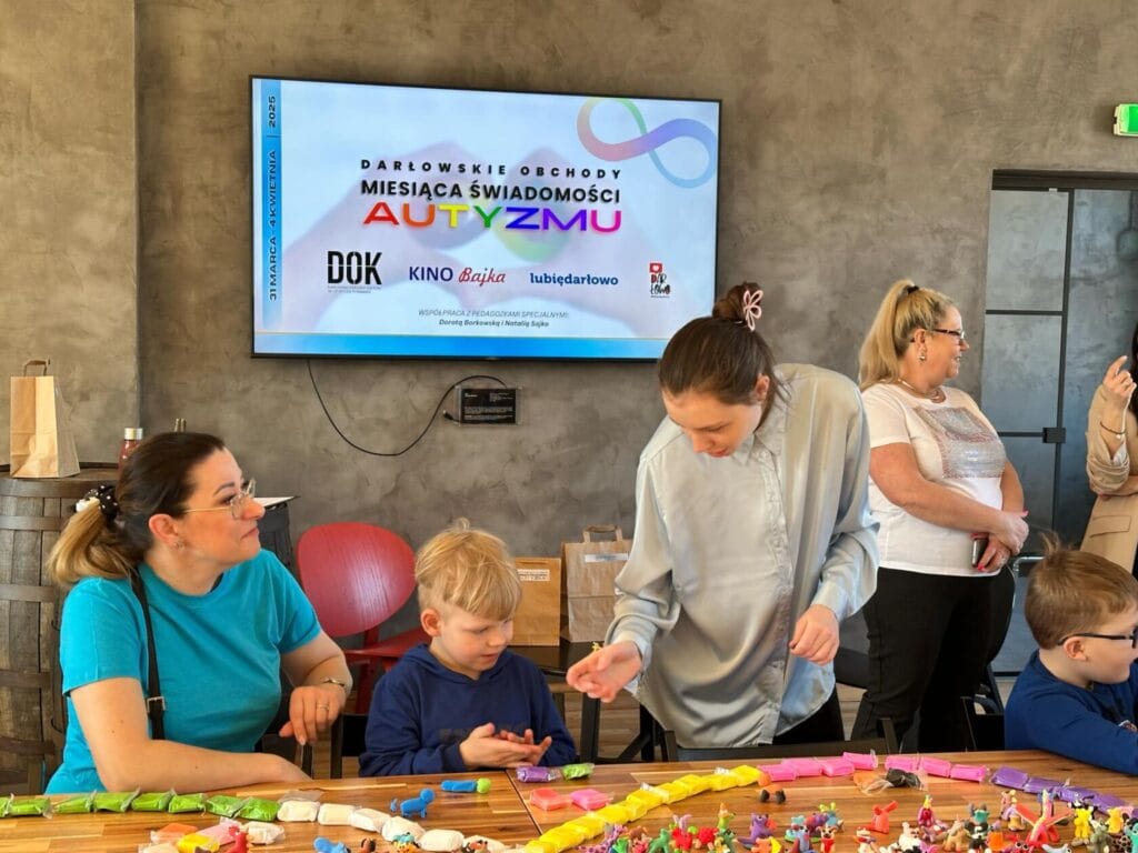 Dzieci i dorośli uczestniczą w warsztatach plastycznych