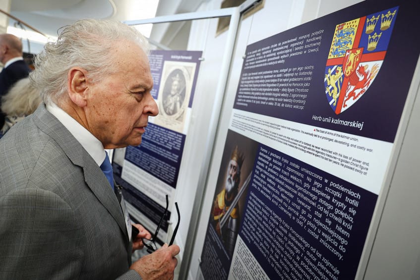 Starszy mężczyzna czyta informacje na wystawie historycznej