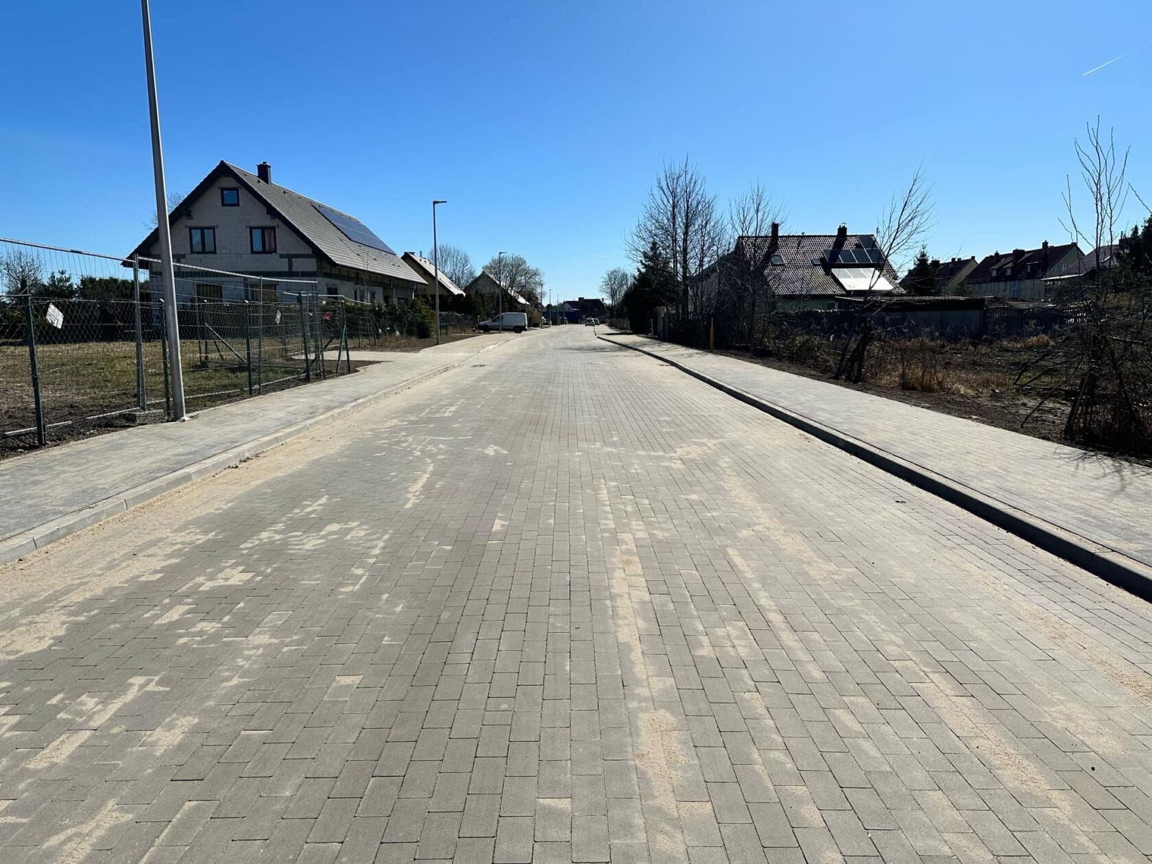 O5-9OfIv Słoneczna ulica z kostki brukowej w dzielnicy mieszkaniowej