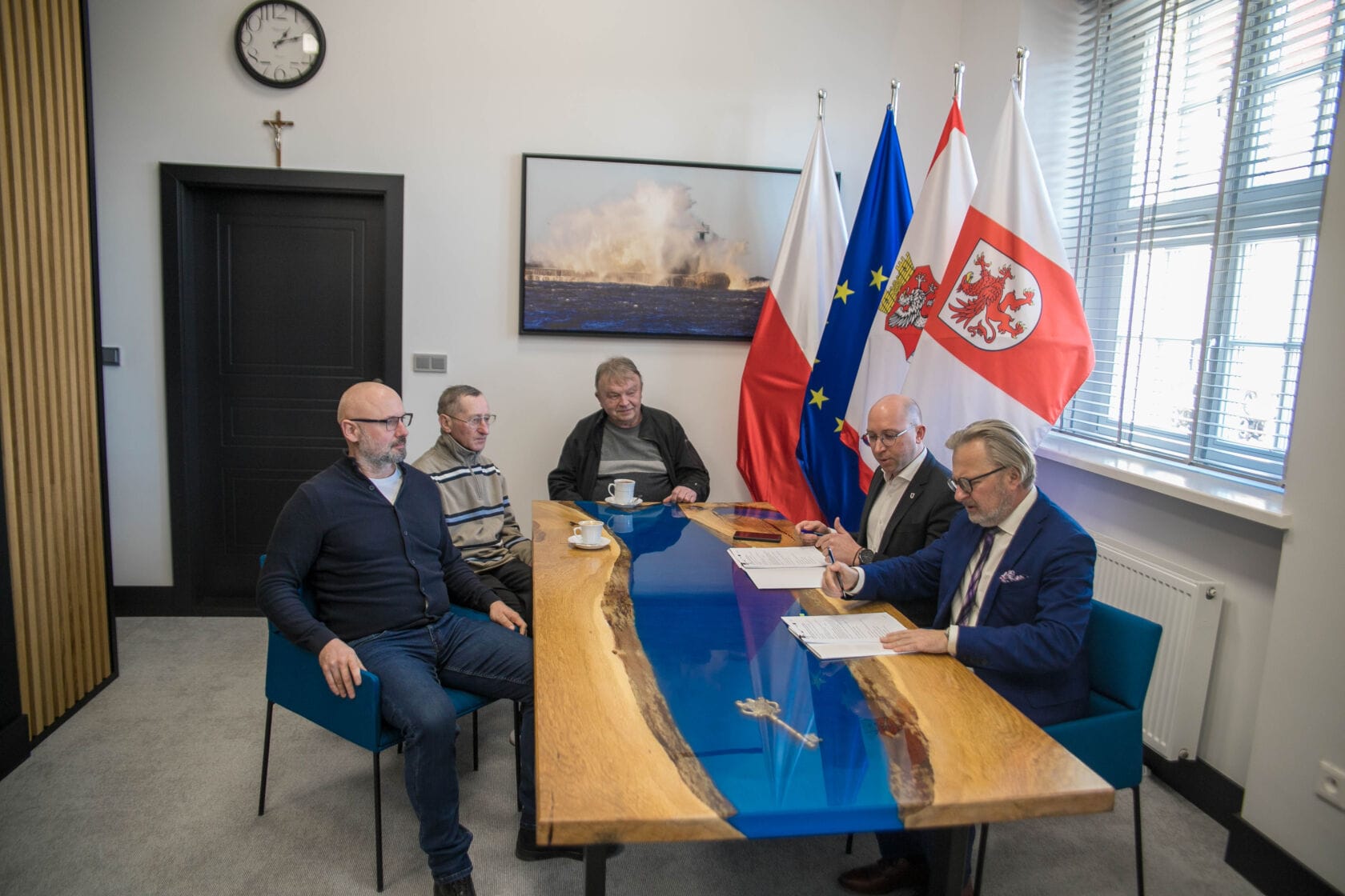 podpisanie umowy w sprawie parku Conrada 2025 Mężczyźni dyskutują przy stole z flagami narodowymi