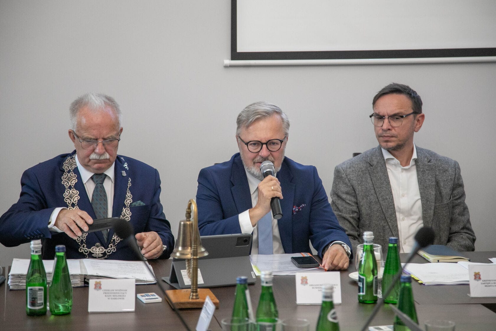 Trzech mężczyzn dyskutuje na konferencji