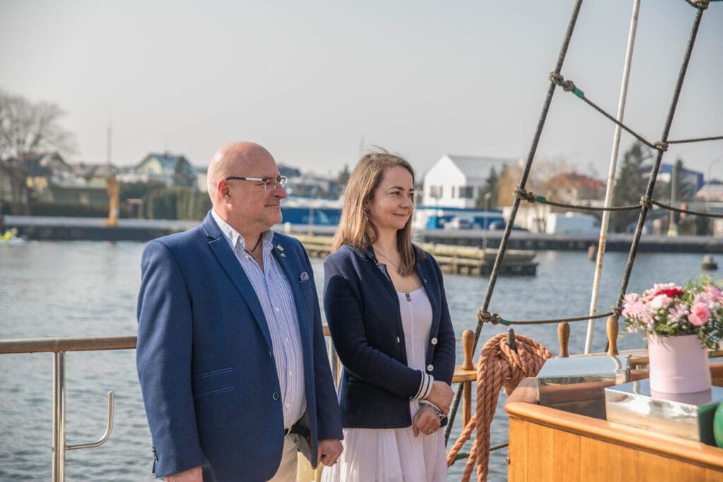 Para obserwująca wodę, stoi na łodzi