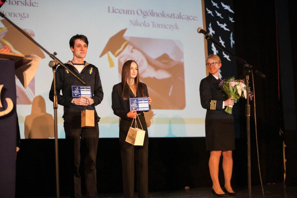 Studenci otrzymują dyplomy na scenie szkolnej ceremonii