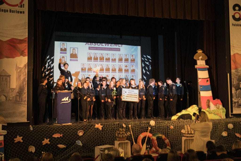 Ceremonia zakończenia roku w szkole morskiej, uczniowie na scenie