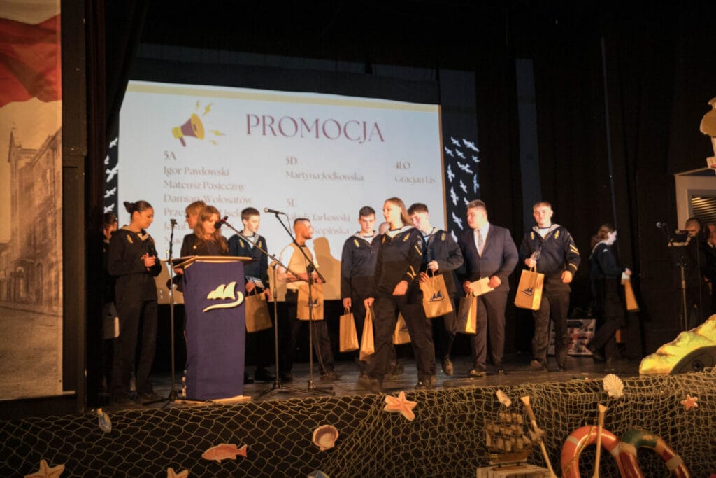 Uczniowie na scenie podczas szkolnej ceremonii promocji