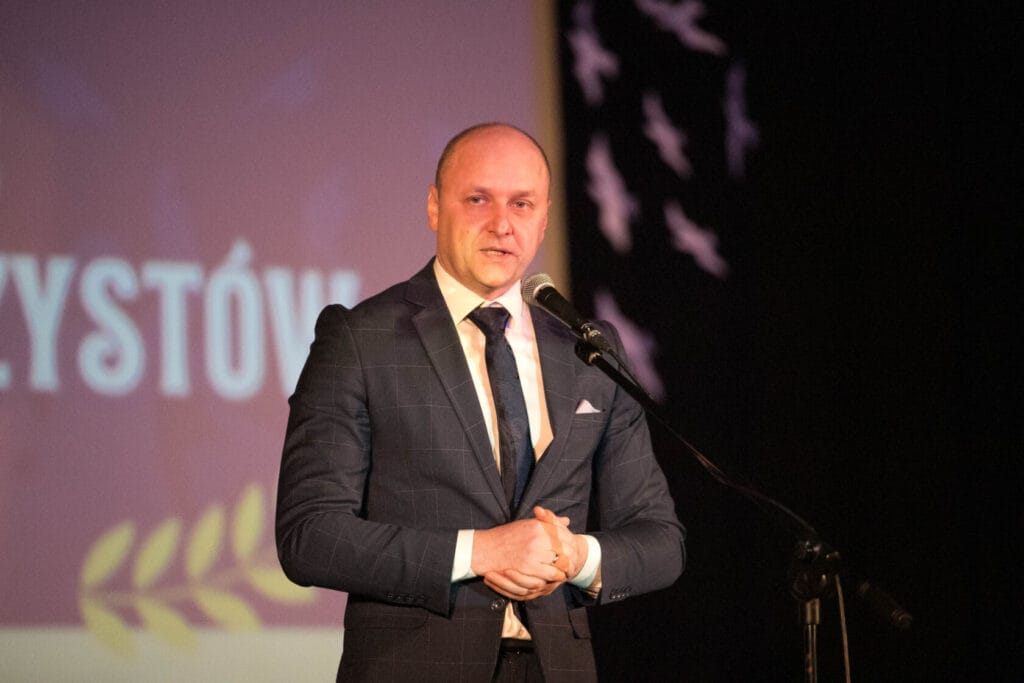 Mężczyzna w garniturze przemawia na konferencji