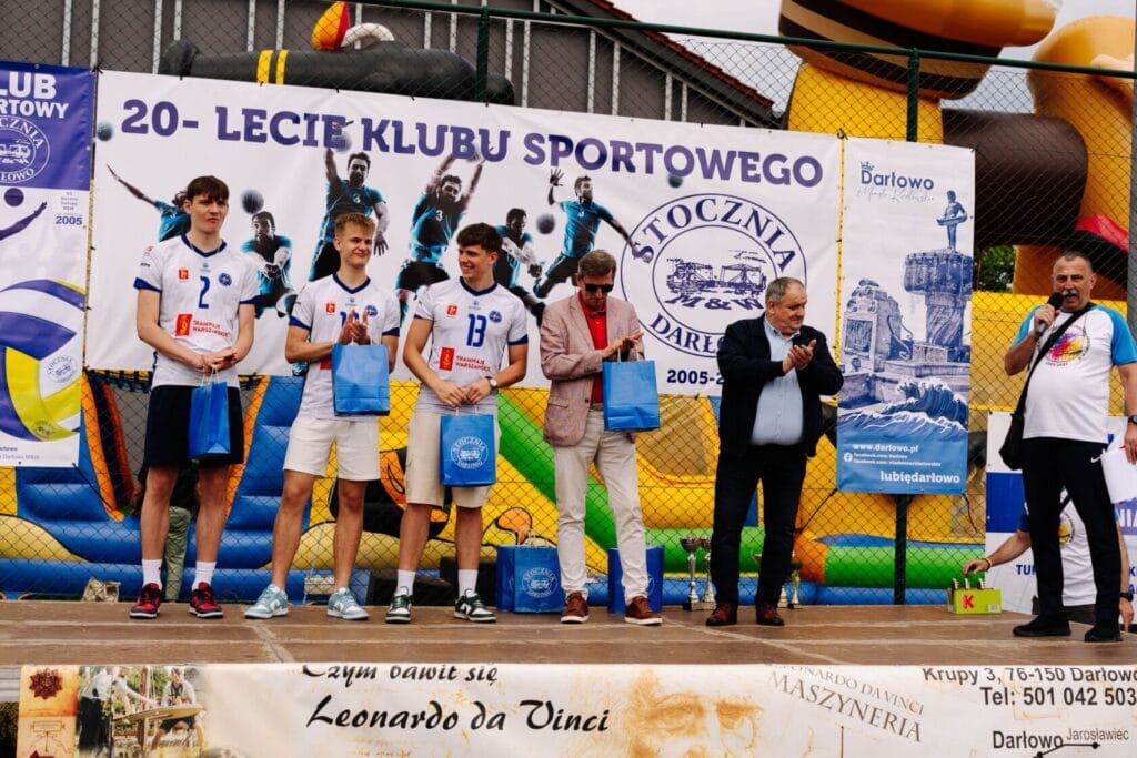 Młodzi sportowcy odbierają nagrody na jubileuszu klubu.