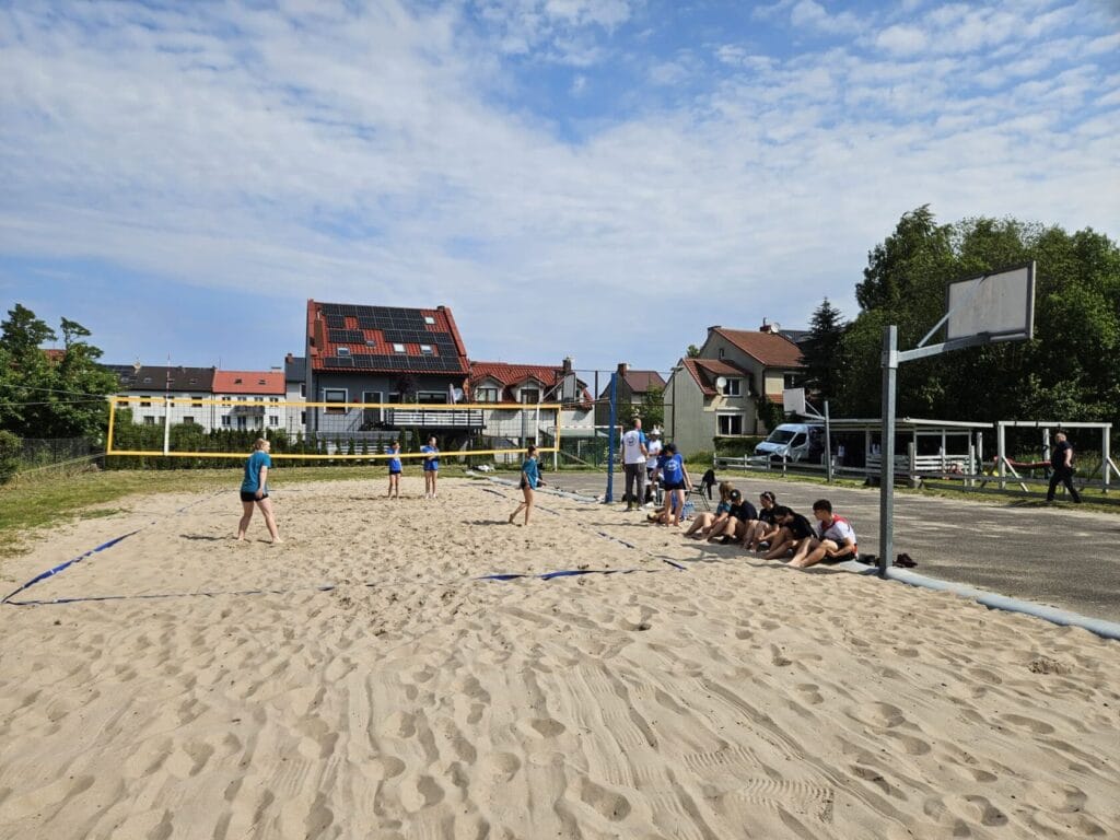 Ludzie grający w siatkówkę na plażowym boisku
